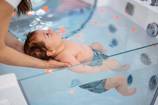 Baby floating in a warm-water hydrotherapy tub